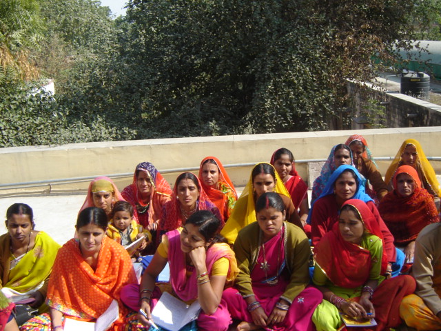 Young women sitting outdoors with notebooks during a learning session