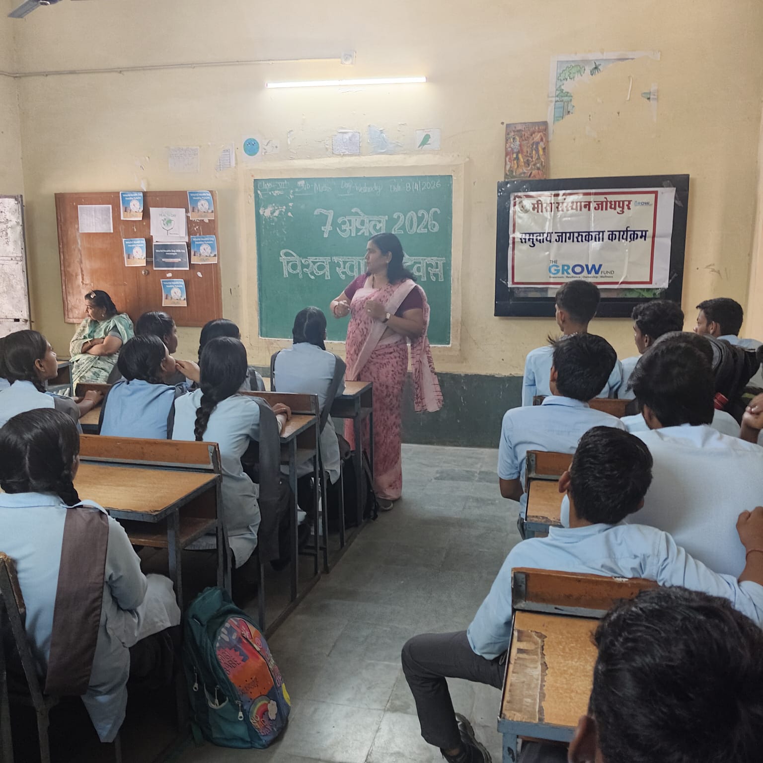 A teacher speaking with students in a classroom