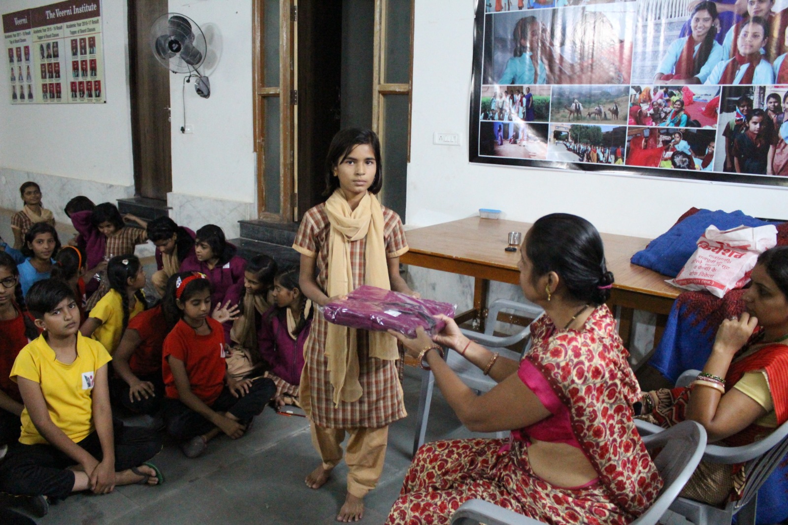A girl receiving learning materials from a teacher