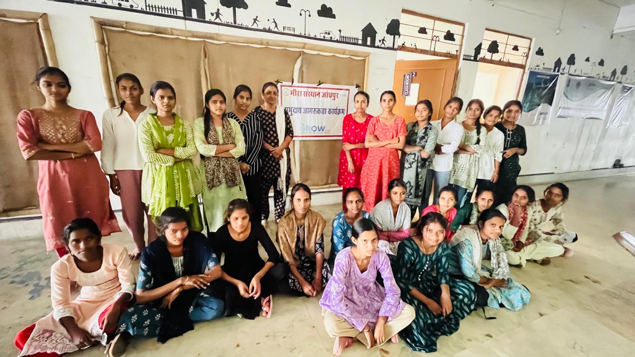 Women gathered with programme staff in front of a GROW banner