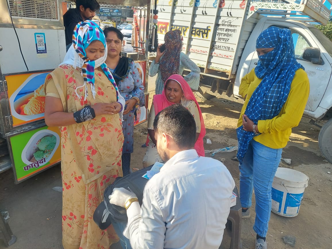 A programme worker sharing information with people outdoors