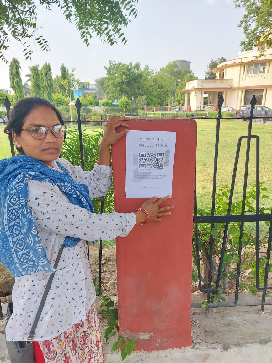 A programme worker standing beside an information box